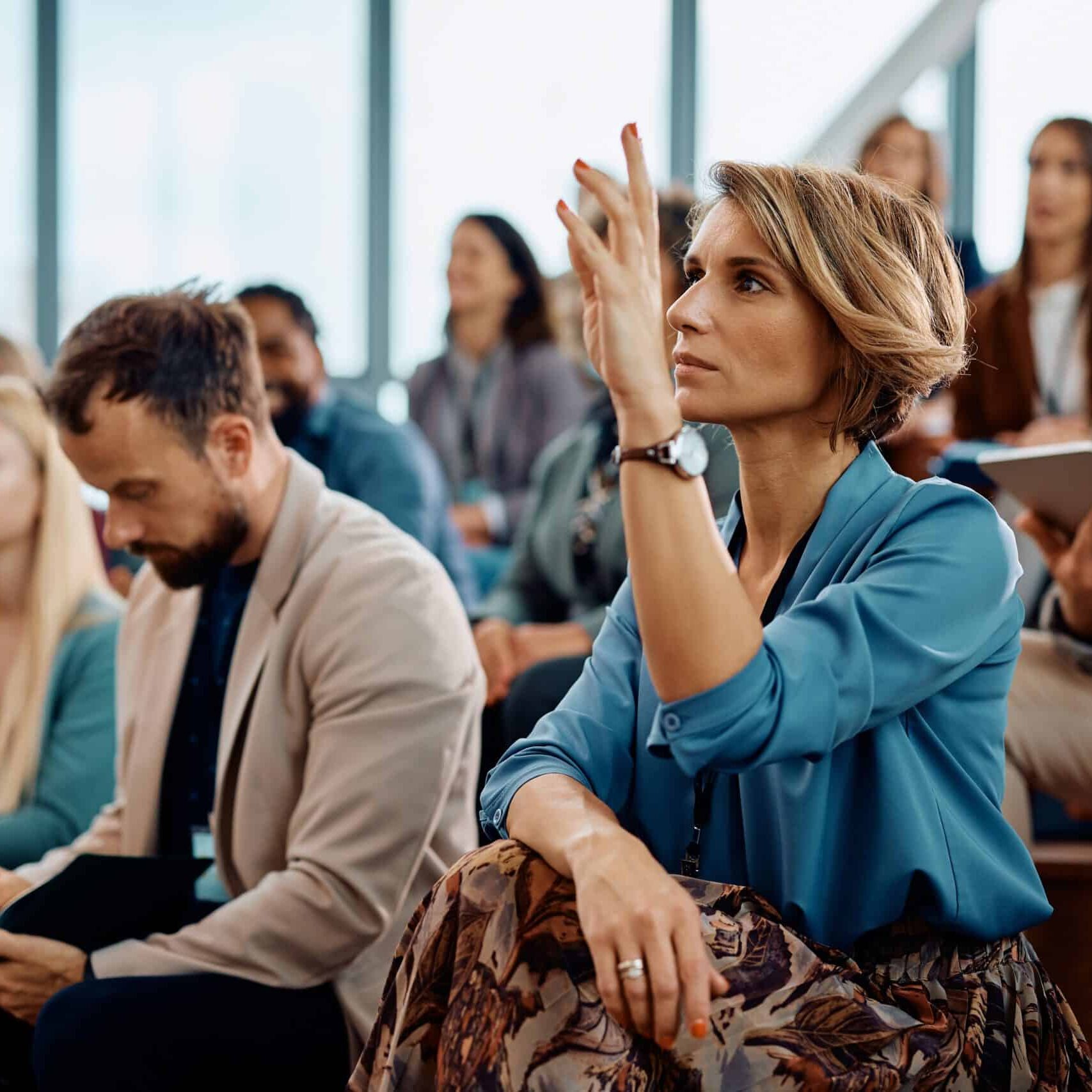 Female,Entrepreneur,Raising,Her,Hand,To,Answer,A,Question,During